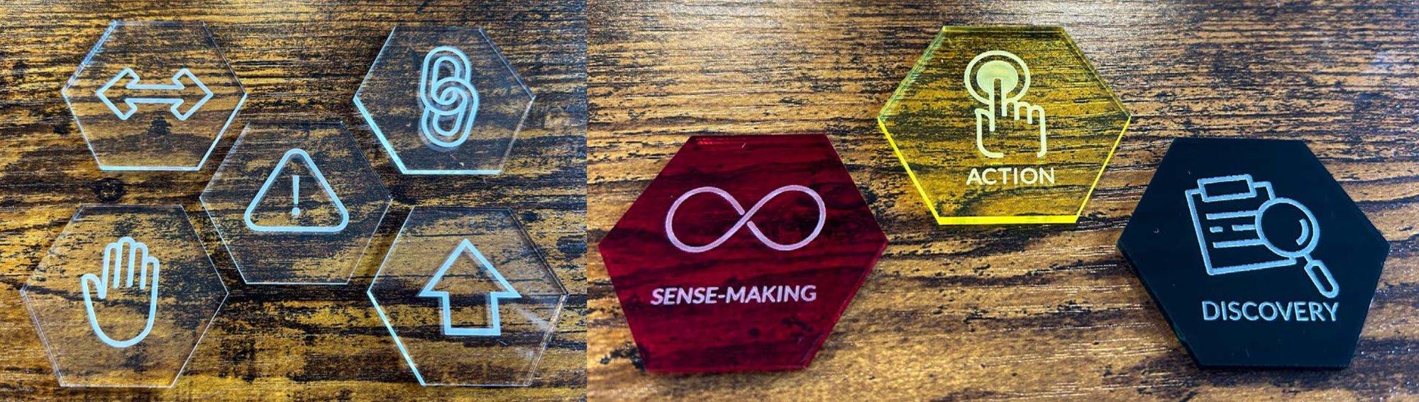 Hexagon tiles made of clear plexiglass / acrylic, in assorted colors. Printed on each is an icon; a few of these also have labels.