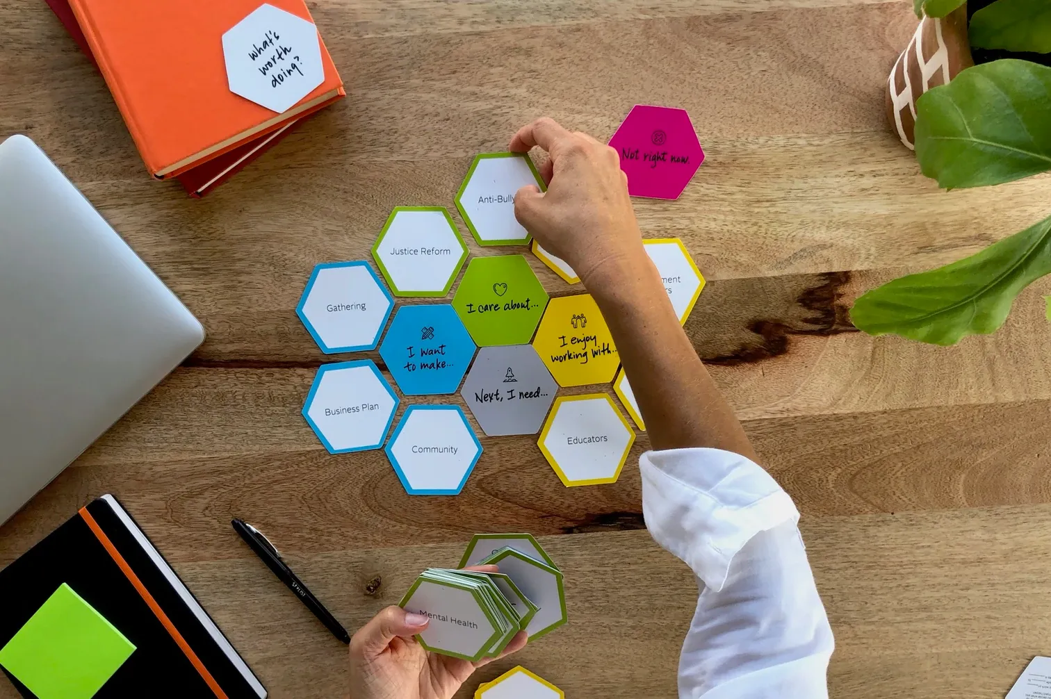 Bird’s eye view of a person at a table, arranging colored hexagon cards.