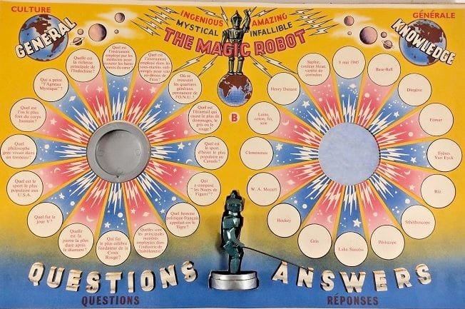 Photo of the vintage board game "The Amazing Magic Robot." We see a symmetrical board, each half depicting a circle of 16 smaller circles, each with text inside. There's a place in the center of each (?) circle where you place a robot figurine.