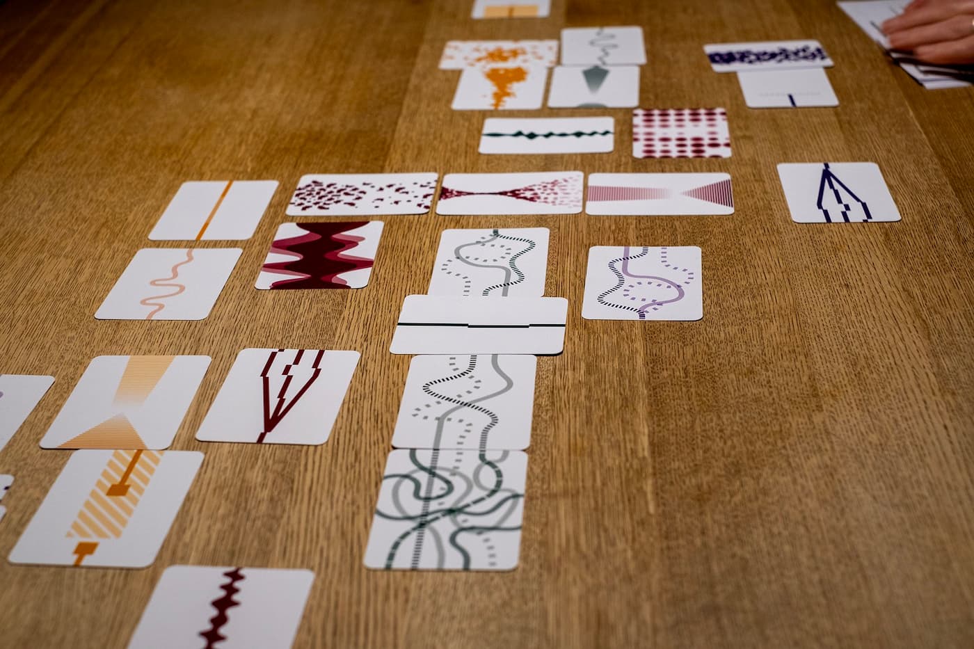 Cards arranged on a table. Each card has an abstract visual representation of time, often resembling a flow of line, waves, or dots from one edge of the card to the other edge.