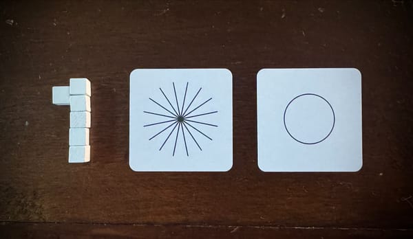 Wooden bits and two cards with circular shapes on them, arranged to form "100"